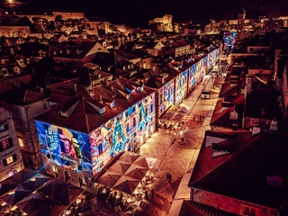 Aerial view of buildings illuminated with vibrant projections, casting a magical glow over the city streets of Dubrovnik, Dubrovnik-Neretva County, Croatia.