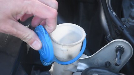 hand open blue cap of water tanker for car windshield wiper and filling clean fresh water to full - Powered by Adobe