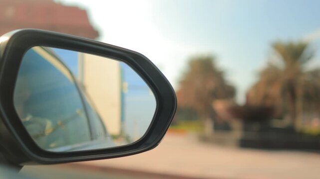 View in the side rearview mirror of a car driving on the city street.
Arabic caption: Objects in mirror are closer than they appear.