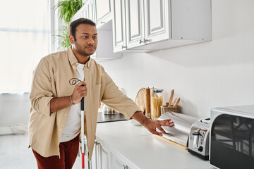 Blind man confidently navigating his kitchen space during a sunny afternoon