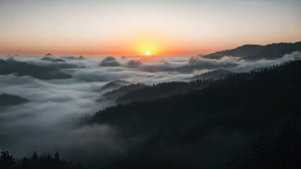 Sunrise over misty mountains with clouds rolling through valleys at dawn