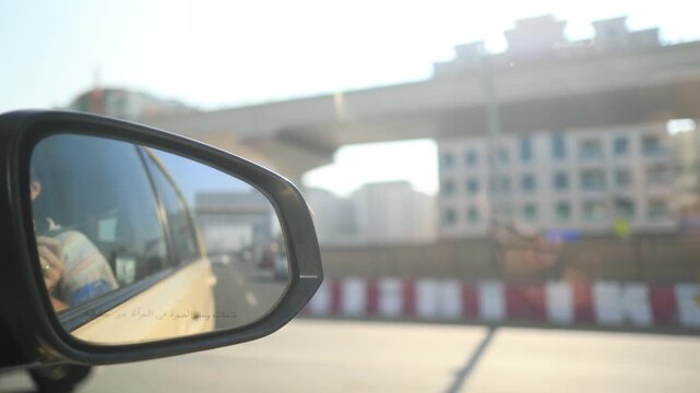 View in the side rearview mirror of a car driving on the city street.
Arabic caption: Objects in mirror are closer than they appear.