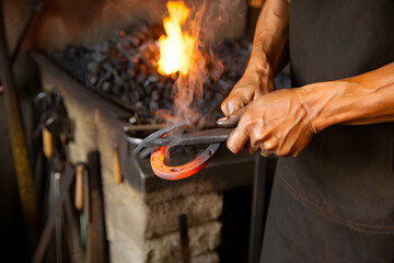 Artisan Metalwork Soot covered hands holding forged metalwork