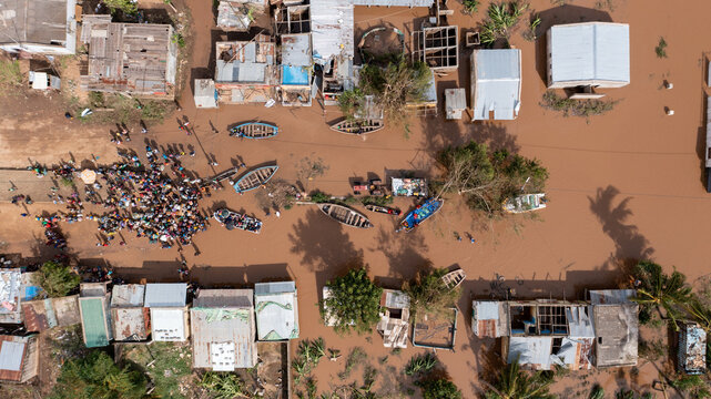 Aerial view of a flooded community where houses and boats are surrounded by muddy floodwaters after heavy rainfall, Sofala Province, Mozambique.