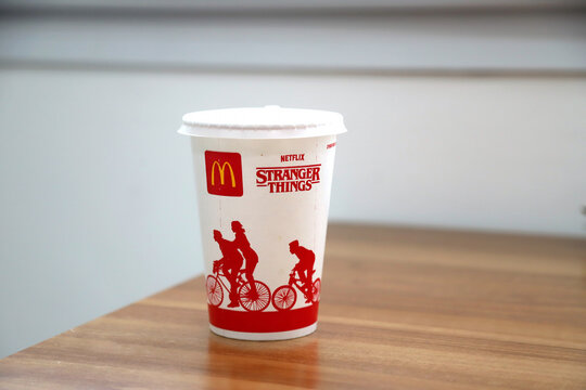 McDonald's cup in collaboration with Netflix's Stranger Things on a wooden table. Isolated