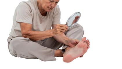 Senior person seated on bedroom floor inspecting their foot with a small mirror emphasizing daily diabetes foot care and neuropathy prevention on white.