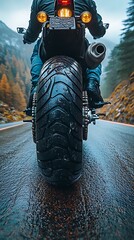 Motorcycle rear view on a wet mountain road in autumn rider driving photo