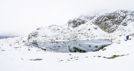 large lagoon in the Sierra de Guadarrama mountains in Madrid during the snowfall of december 2025, at the Cotos mountain pass