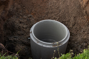 Installation of a reinforced concrete well for water supply and sewerage at a construction site. Concrete well ring