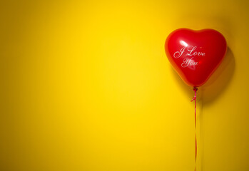 Red heart balloon with love message floating on bright yellow background for Valentine’s Day romance concept and modern design use