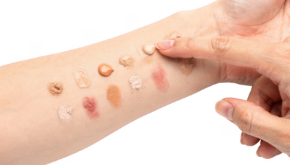 Closeup of hand applying a cosmetics patch test on inner forearm against a white background highlighting skin reaction for safe makeup use at home.