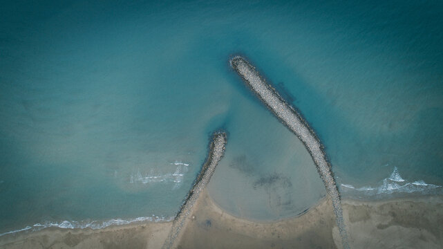 Aerial view of the breakwater stretching into the turquoise sea at Narbonne Plage, creating a striking contrast between the stone and water, Narbonne plage, France.