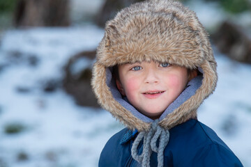 Young Boy Bundled Up with a Fur Cap on a Cold Winter Day