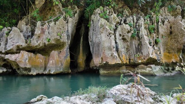 Pum Pum Rock within Bag Walk Gorge, capturing the raw beauty of flowing freshwater, limestone rock formations, and lush tropical surroundings.