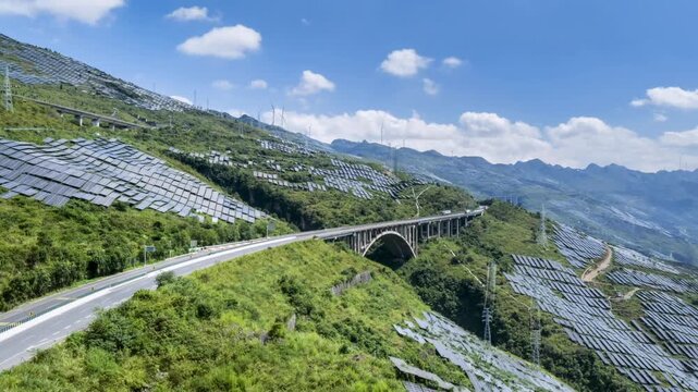 aerial time-lapse of the Shanghai&ndash;Kunming Expressway and high-speed rail through vast mountain solar farms under clear blue skies, green infrastructure and clean energy in Guizhou, China