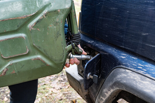 Hand person refueling off-road vehicle from jerry can