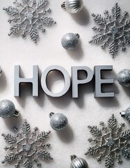 Top view of silver 3D Hope written on white glitter background with silver snowflake decorations 