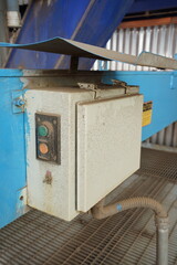 Industrial control panel with buttons and wiring in a factory setting