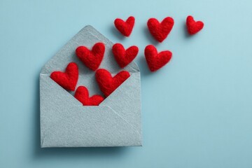 Creative romantic message concept with red heart shapes and minimalist white envelope