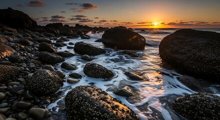 Sunset over the rocky coastline with waves and golden light.