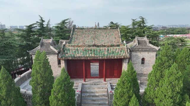 Traditional Chinese Temple in Shangqiu with Cypress Trees and Red Doors