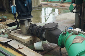 Robust industrial pumping and piping infrastructure with a powerful motor and control valves managing fluid flow in a processing plant environment, showcasing heavy-duty machinery and connections