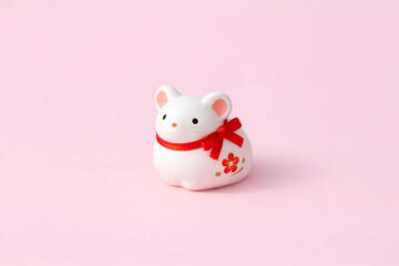 Cute White Mouse Figurine with Red Ribbon on Pink Background