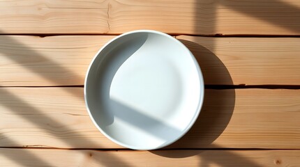 clean white ceramic plate mockup on natural wooden table with soft sunlight and shadow
