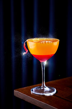 Orange and Rhubarb Fizz Cocktail with citrus twist on a dark background 