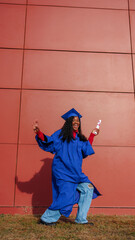 Black woman celebrating academic achievement with a diploma and graduate cap