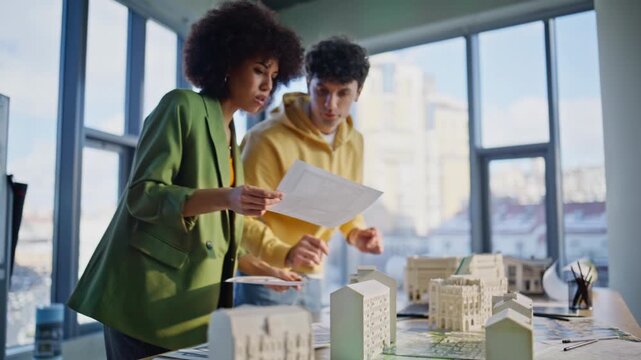 Two architects working constructions documentation in building company office.