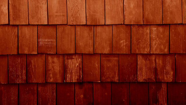 Old red or brown rustic wood shingles texture background. Red weathered cedar shake wall siding. Grunge timber roof surface pattern with rough vertical grain details for architectural design.