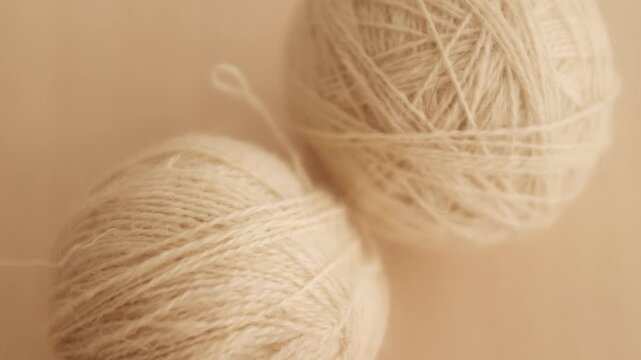 Wool yarn thread for knitting and crocheting. Warm clothes knitting hobby and crafts, slow living concept, textile industry. Closeup slow motion aesthetic video.