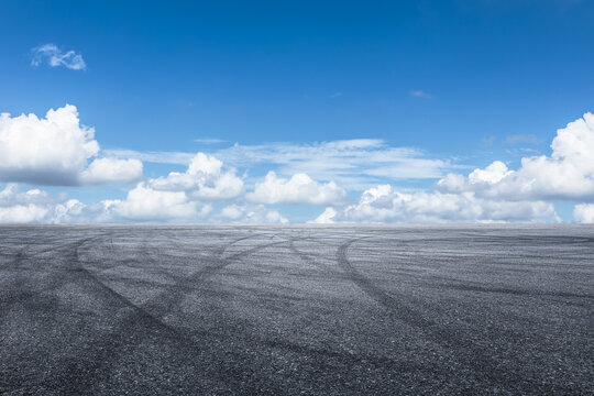 Empty asphalt road and blue sky with clouds background.