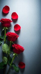 Red roses with scattered petals on soft gray background for romantic design