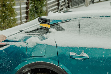 Brushing Snow Off a Car Windshield in Winter