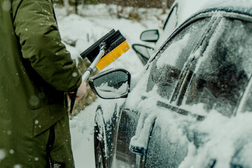 Brushing Snow Off a Car Windshield in Winter