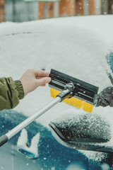 Brushing Snow Off a Car Windshield in Winter