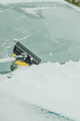 Brushing Snow Off a Car Windshield in Winter