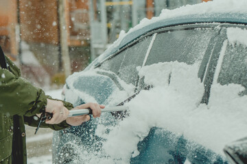 Brushing Snow Off a Car Windshield in Winter