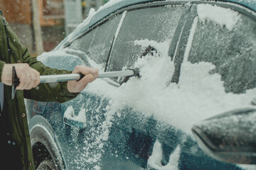 Brushing Snow Off a Car Windshield in Winter
