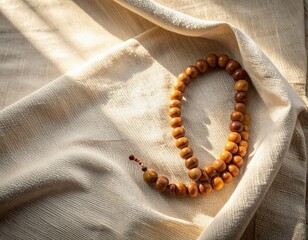 Spiritual Prayer Beads Resting on Textured Fabric with Warm Sunlight and Shadow Patterns
