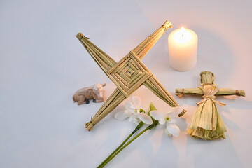 Brigid's cross, corn dolly and candle celebrating imbolc
