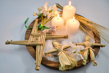 Imbolc altar with brigid's cross, candles, and corn dollies
