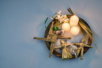 Imbolc altar presenting brigid's cross, candles, and corn dolls