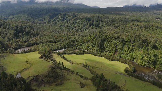Aerial View of Valley and River Separating Forest with Mountain Background