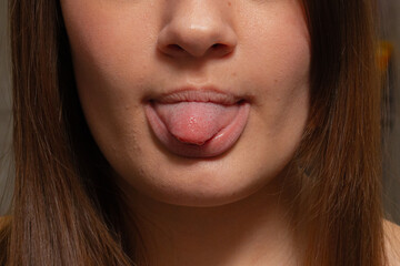Vibrant Indoor Shot Of Youthful Woman Teasingly Sticking Out Her Tongue With Playful Charm
