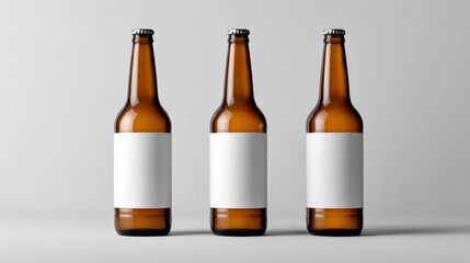 Three amber glass bottles with blank white labels and metallic caps are centered against a gray backdrop, ready for design