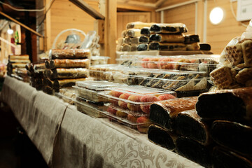 Market stall filled with assorted traditional sweets packed in clear containers. The scene reflects abundance, craftsmanship, and everyday street food culture.