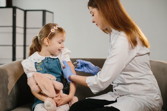 Girl receiving vaccination shot from doctor